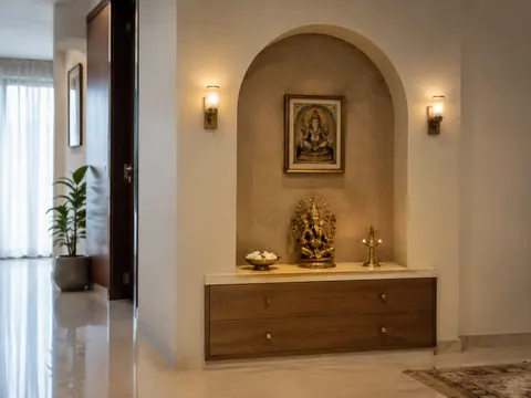 Arch-frame mandir: Shallow arched recess, Warm plaster finish and Stone shelf